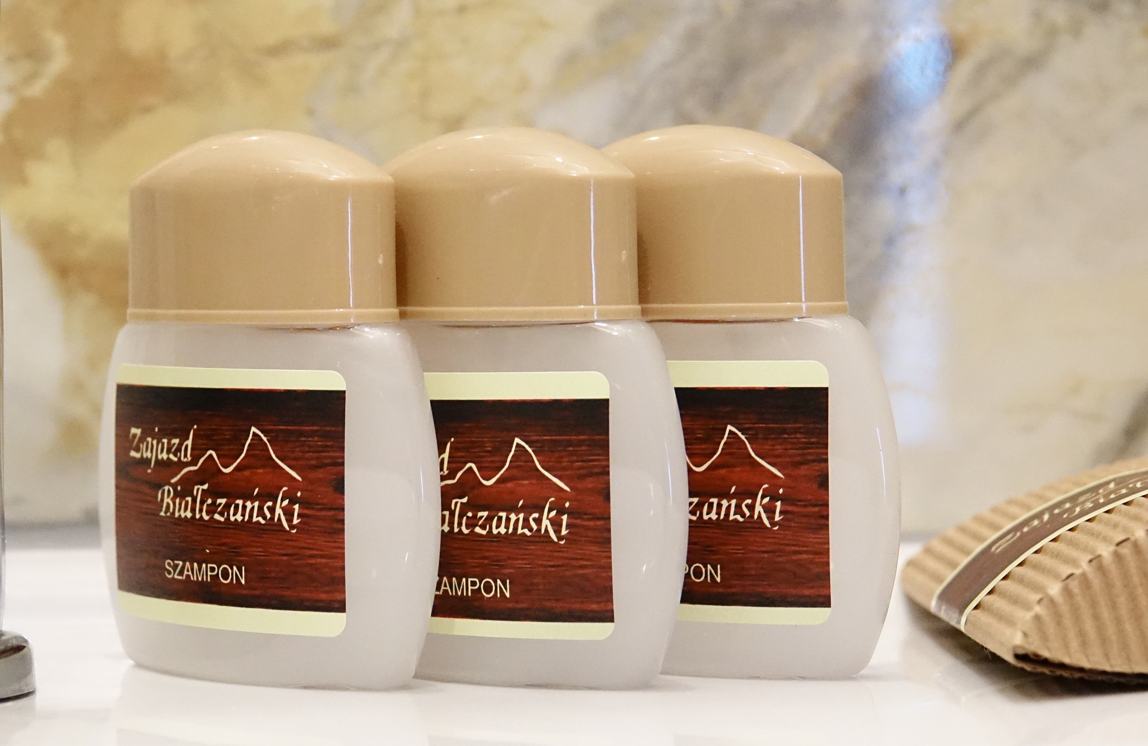 Tres botellas de champú con etiquetas de madera.