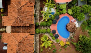 Relax by the pool surrounded by lush greenery and seating areas.