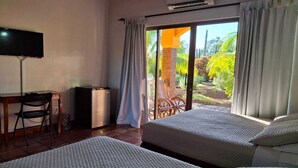 Une chambre d’hôtel avec deux lits, un bureau, une chaise et un téléviseur.