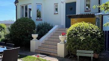 Stylish two-story home with a balcony, patio area, and entrance.