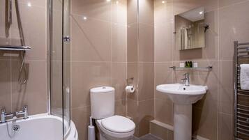 A modern bathroom with a glass-enclosed shower, a white toilet, and a pedestal sink.