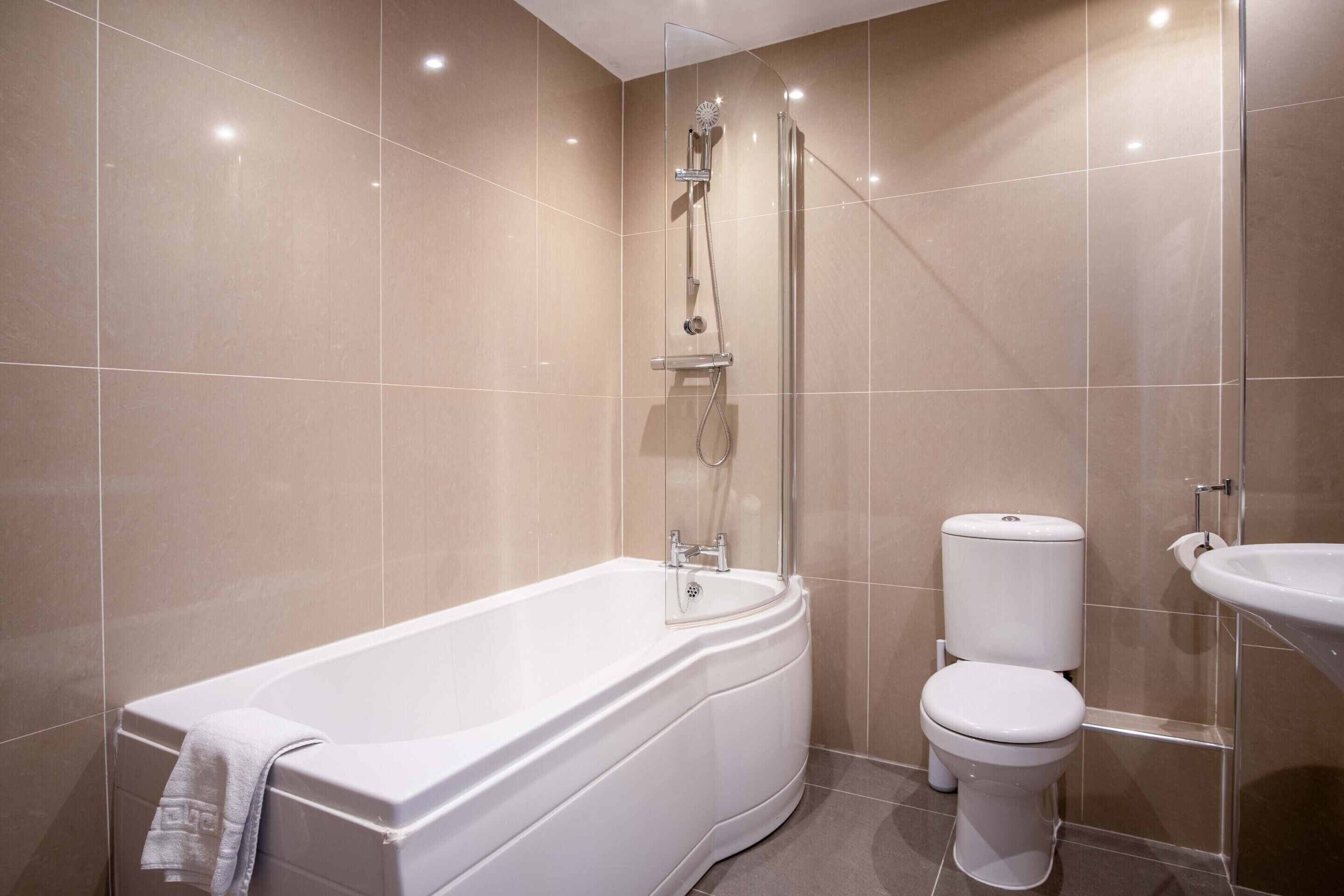 A modern bathroom with a freestanding bathtub, a toilet, and a sink.