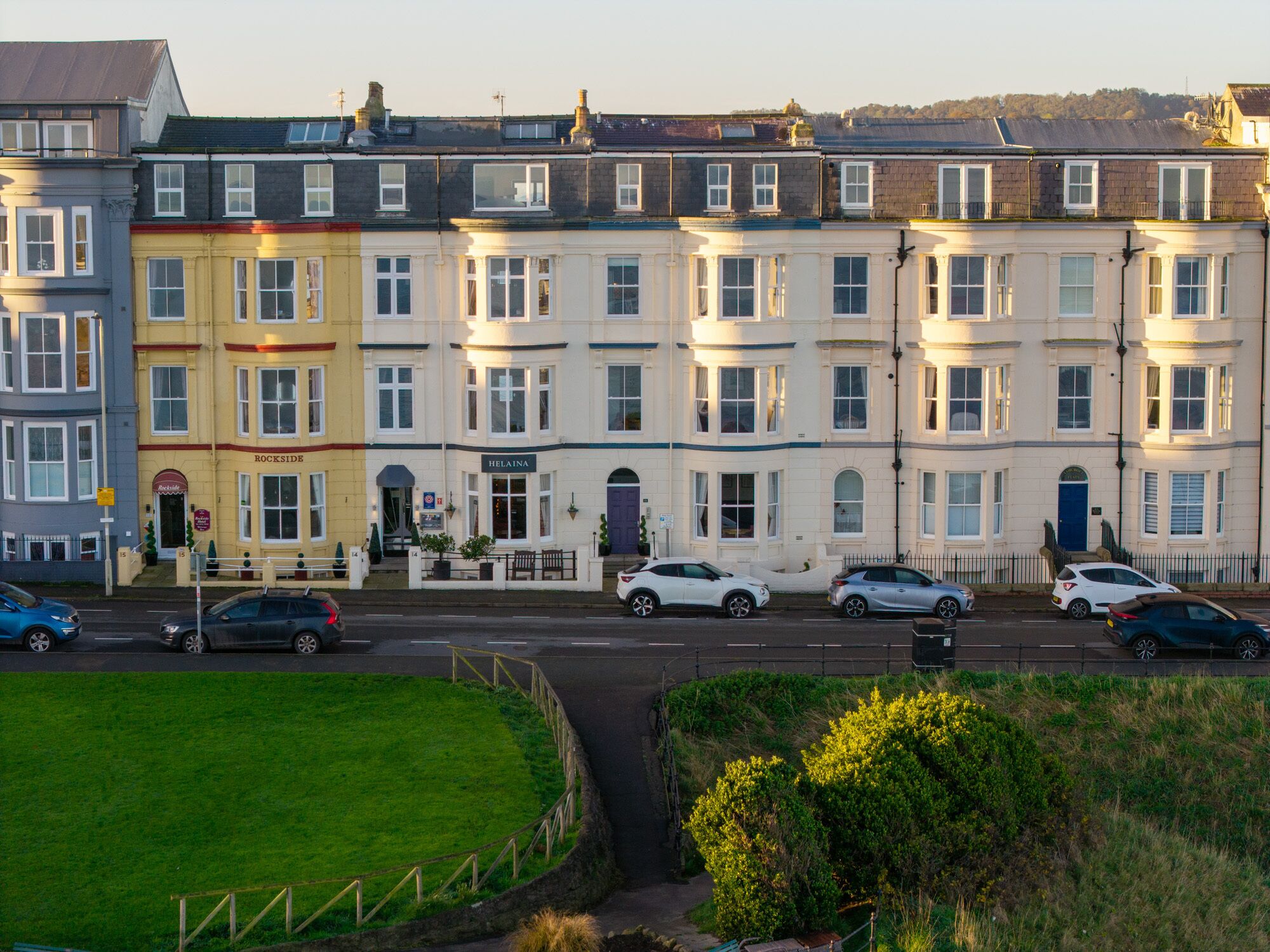 A row of terraced houses with a pub named "Rockside" and a restaurant named "Helaina" on the ground floor.