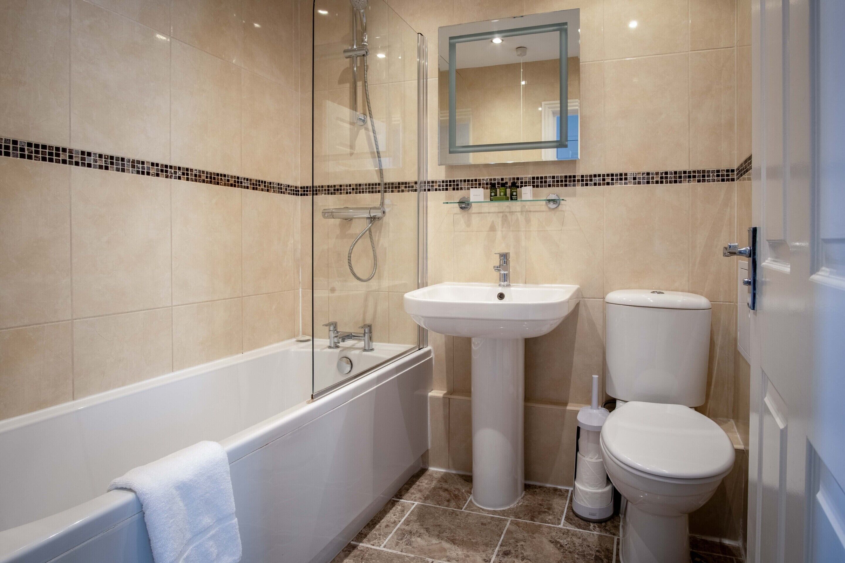 Un baño moderno con bañera, lavamanos e inodoro.