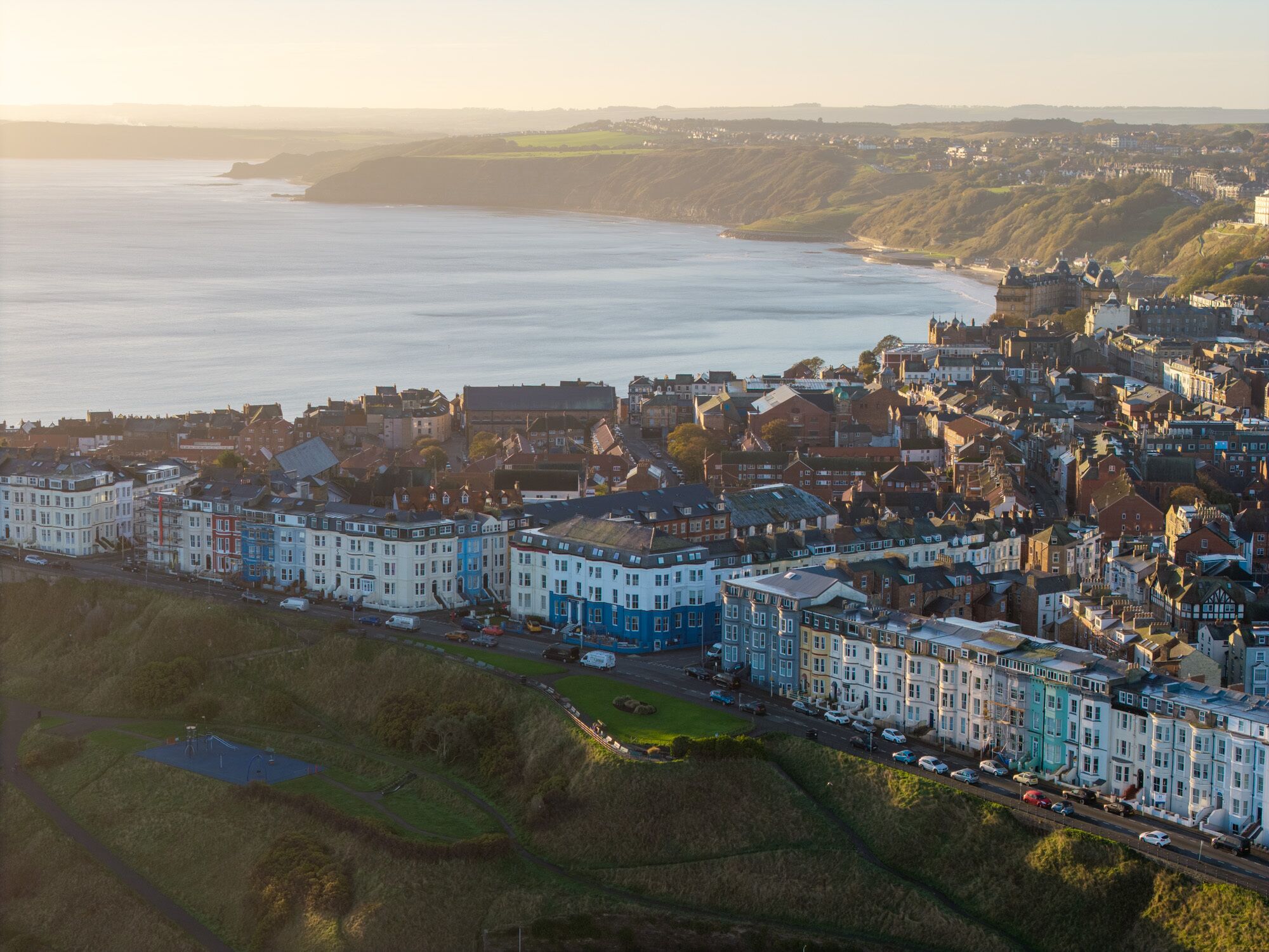 A coastal town with a mix of residential and commercial buildings, a prominent waterfront, and a park area.