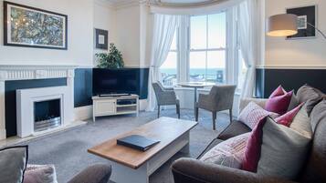 A modern living room with a fireplace, a television, and seating arrangements.