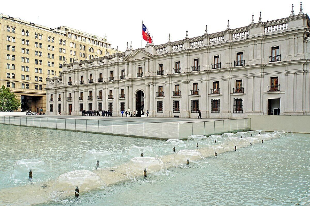 A large building with a fountain in front.
