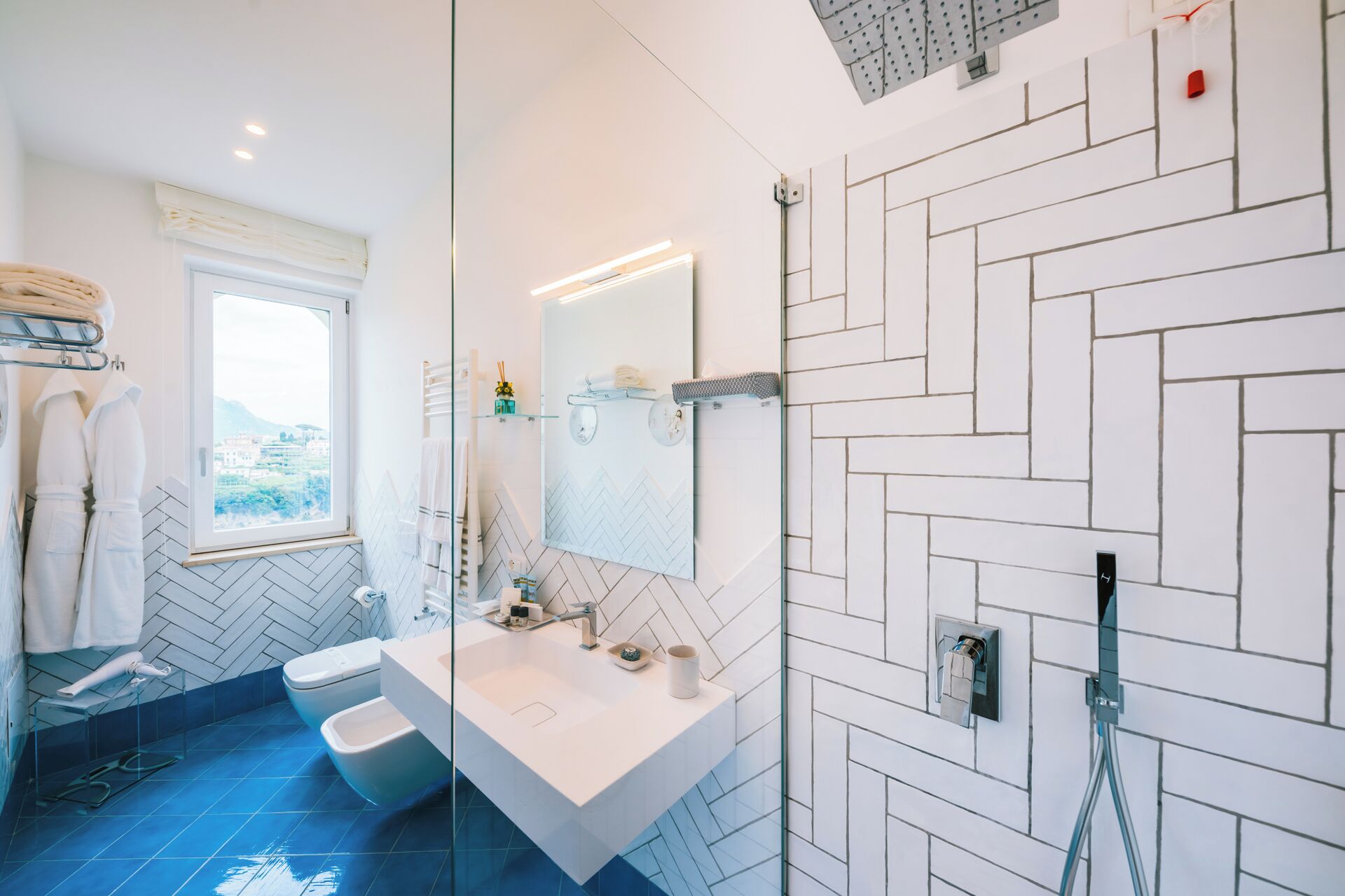 A modern bathroom with a large mirror, a white sink, and a shower area.