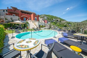 A poolside area with lounge chairs and tables, a swimming pool, and a hillside view. - Palazzo Pascal - Amalfi Coast Luxury Experience (Scala)
