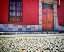 Un edificio rojo con puerta y ventana de madera.