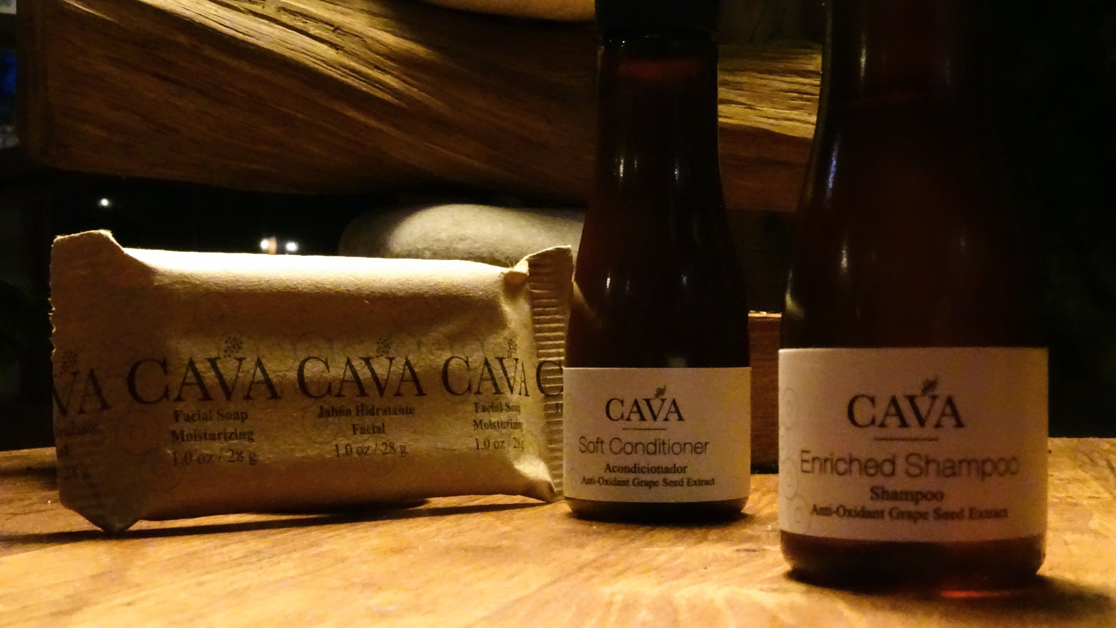 Trois bouteilles de cava sur une surface en bois.