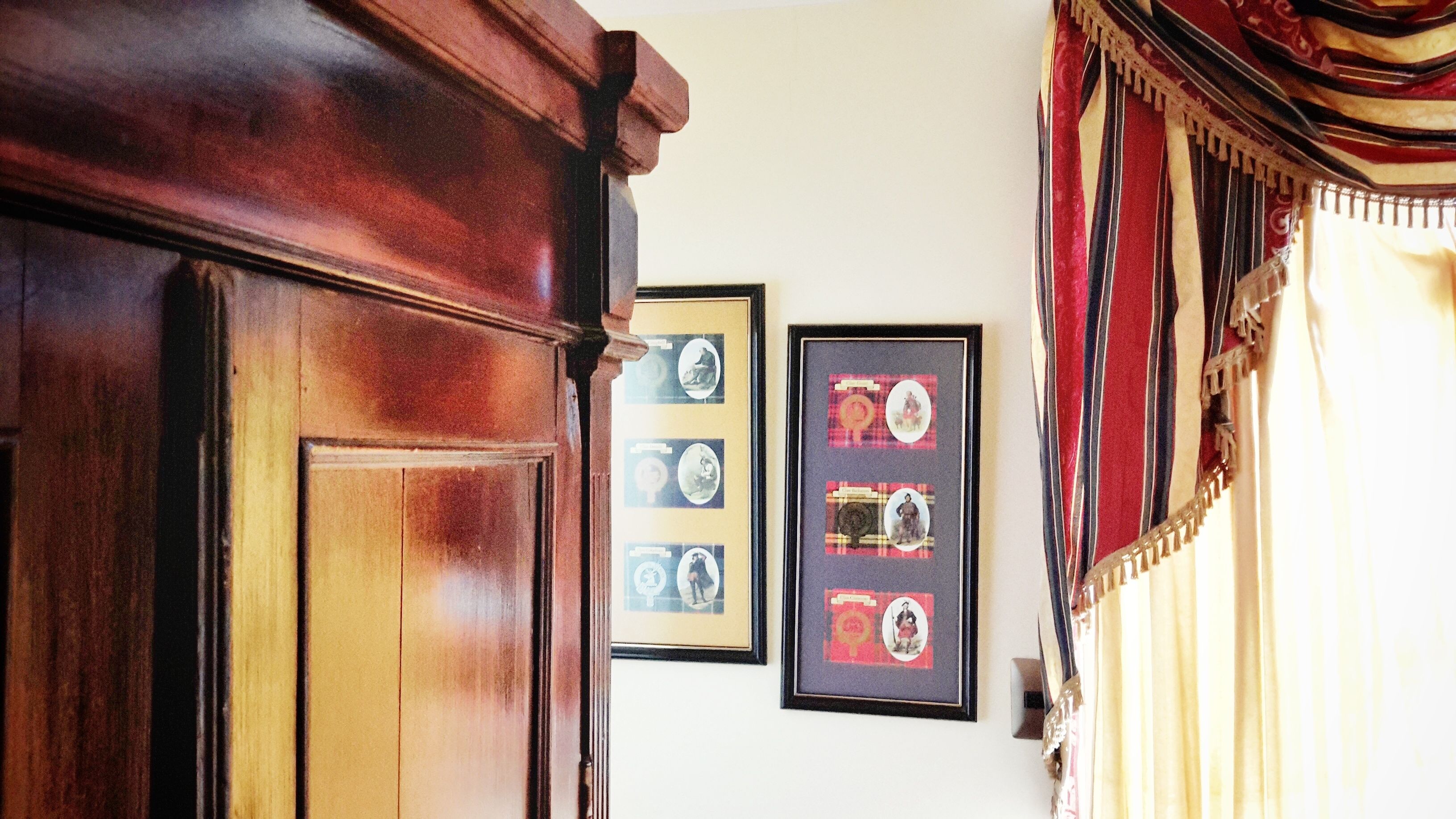 A wooden door with a mirror and a framed picture of a woman on the wall.