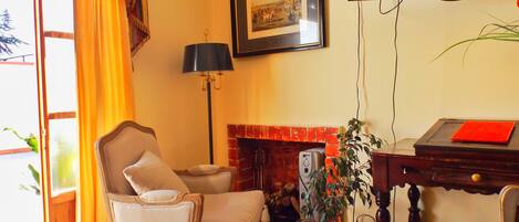 A living room with a fireplace, a framed picture on the wall, a lamp, and a television.