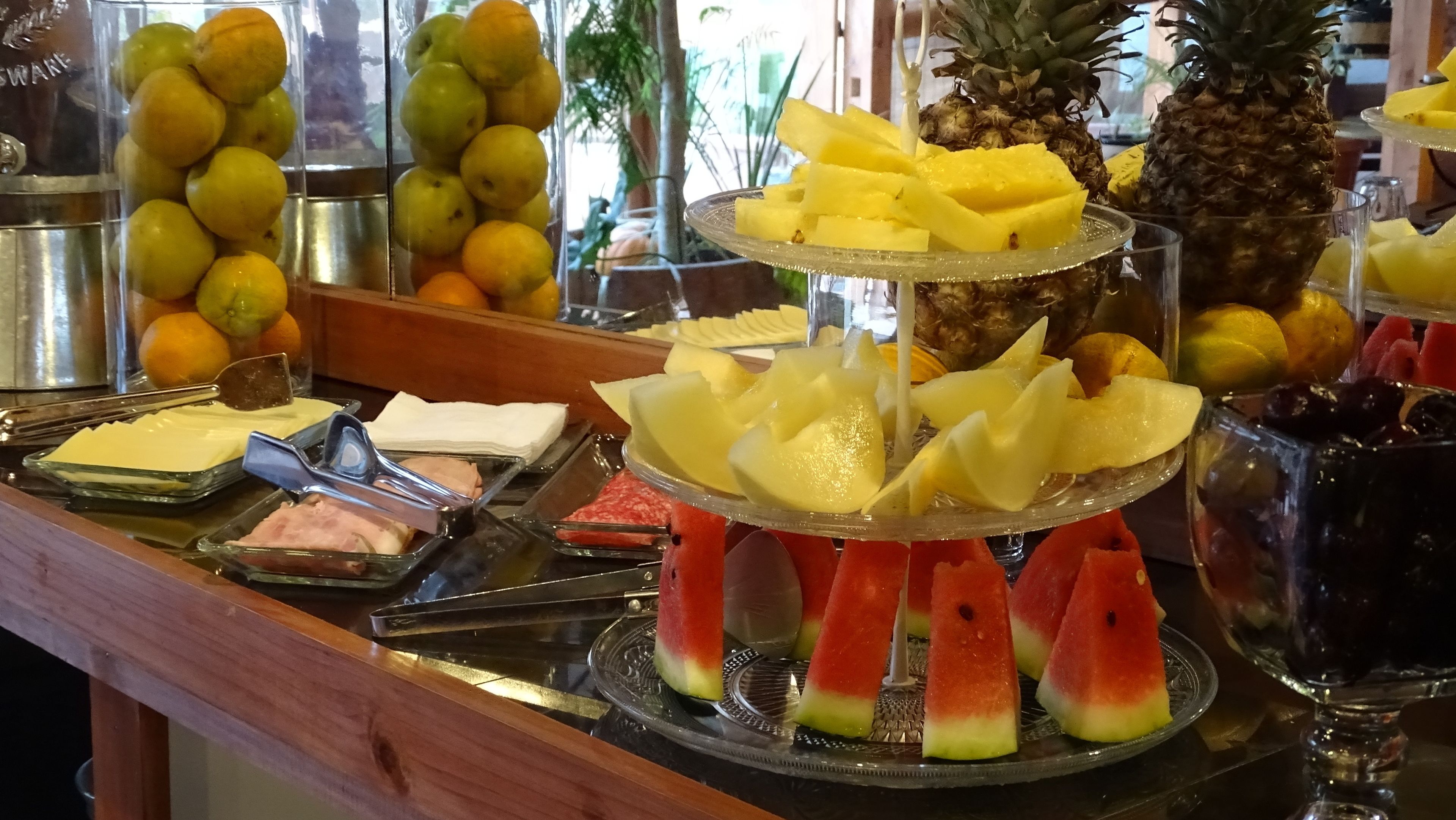 Un bufé con diversas frutas y una piña.