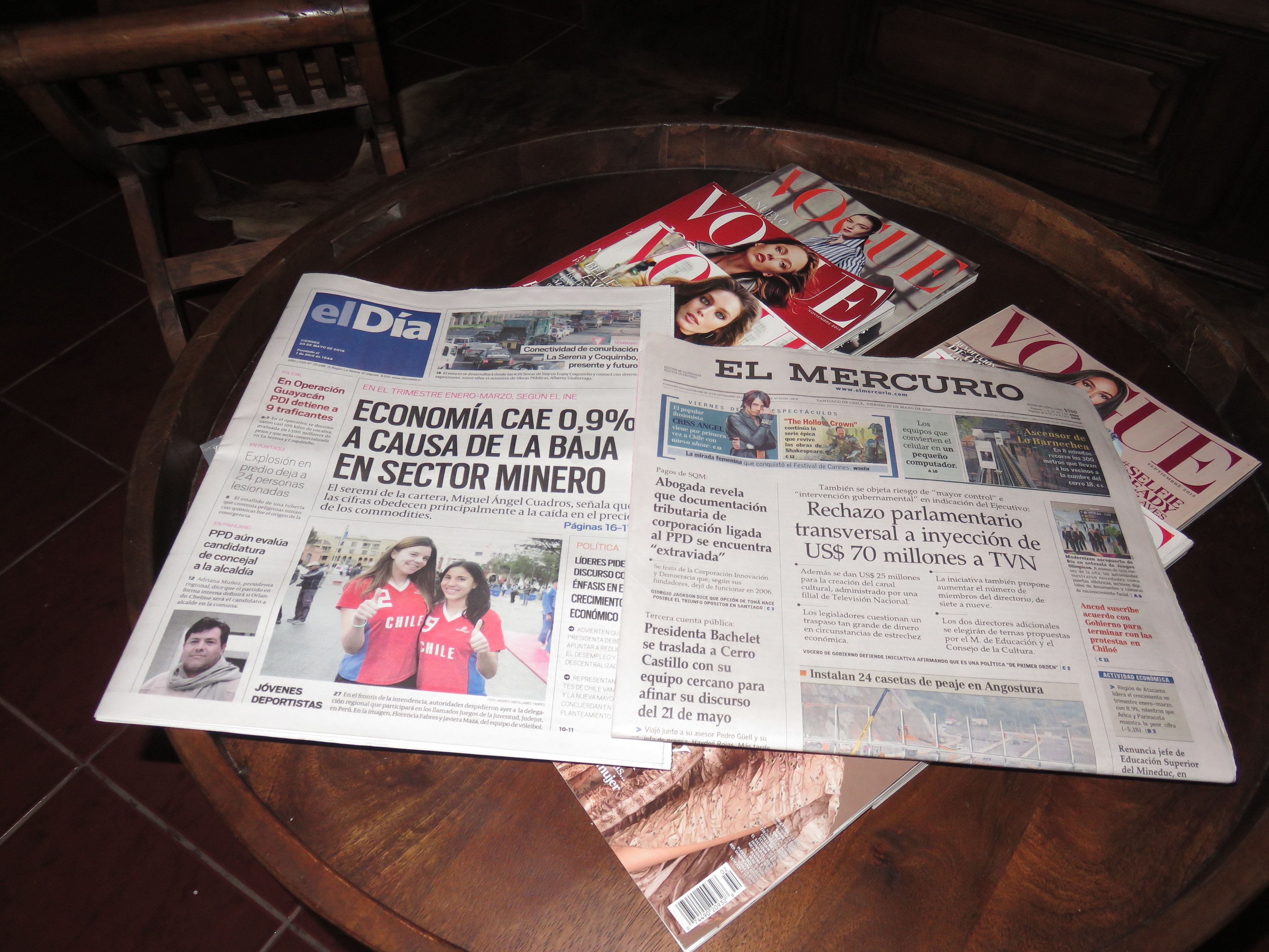 A table with newspapers and magazines, including 'El Dia' and 'El Mercurio'.