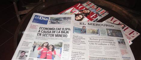 A table with newspapers and magazines, including 'El Dia' and 'El Mercurio'.