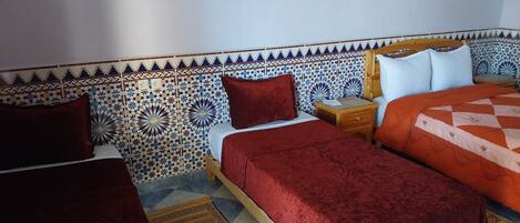 Una habitación con una cama, una mesita de noche, un cabecero de madera y una pared con diseño.
