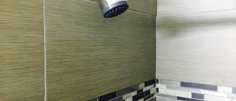 Um chuveiro com design moderno, com acabamento metálico e um chuveiro de design preto.
