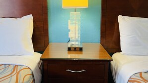 A hotel room with a wooden nightstand, a lamp, and a drawer. - Relax Inn Lawton (Lawton)