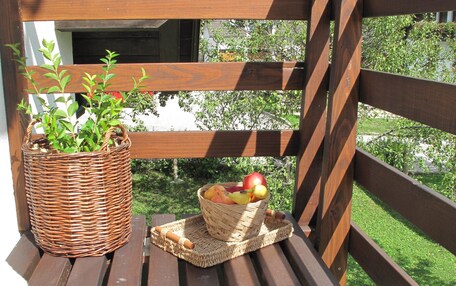 A wooden deck with a wicker basket and a woven placemat holding a fruit bowl.