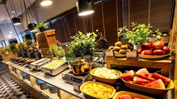 A buffet with various food items, including fruits and vegetables, and a coffee machine. - Novotel Wroclaw Centrum (Wroclaw)