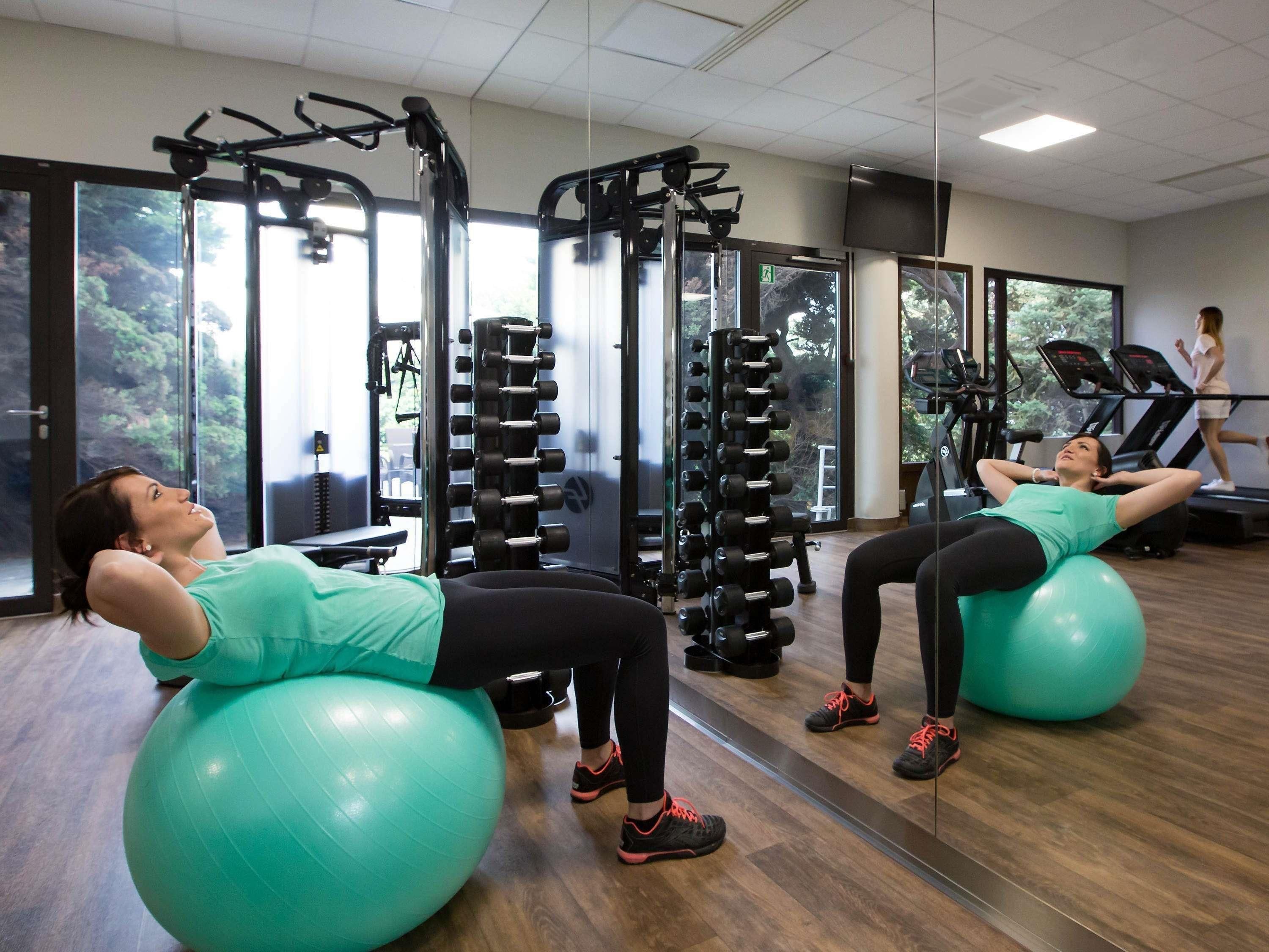 A gym with exercise balls, weight machines, and treadmills.