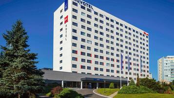 Ein Novotel Hotel mit modernem Design, mehreren Stockwerken und einem überdachten Eingang.