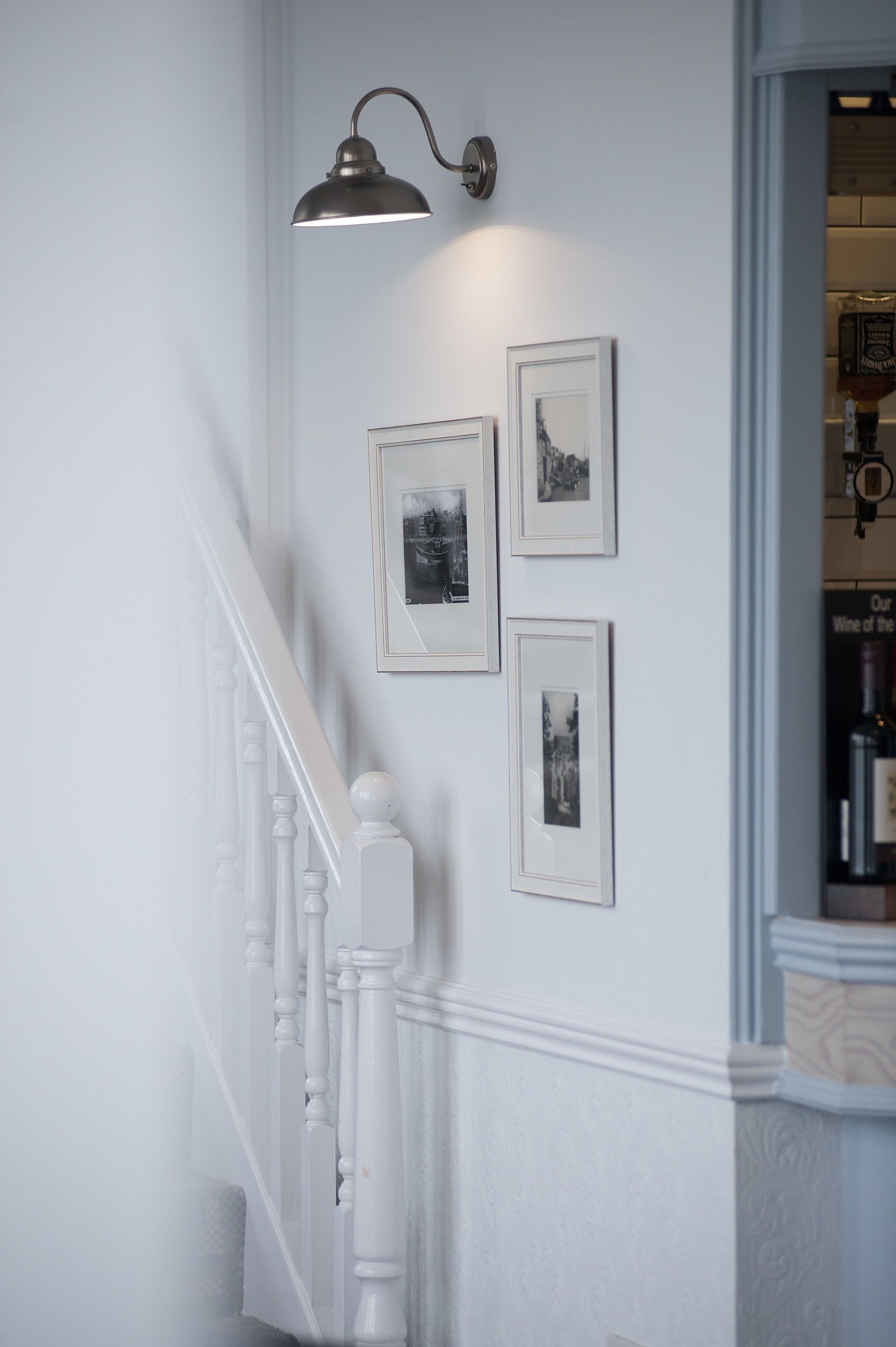 A staircase with white balusters and a wall-mounted light fixture.