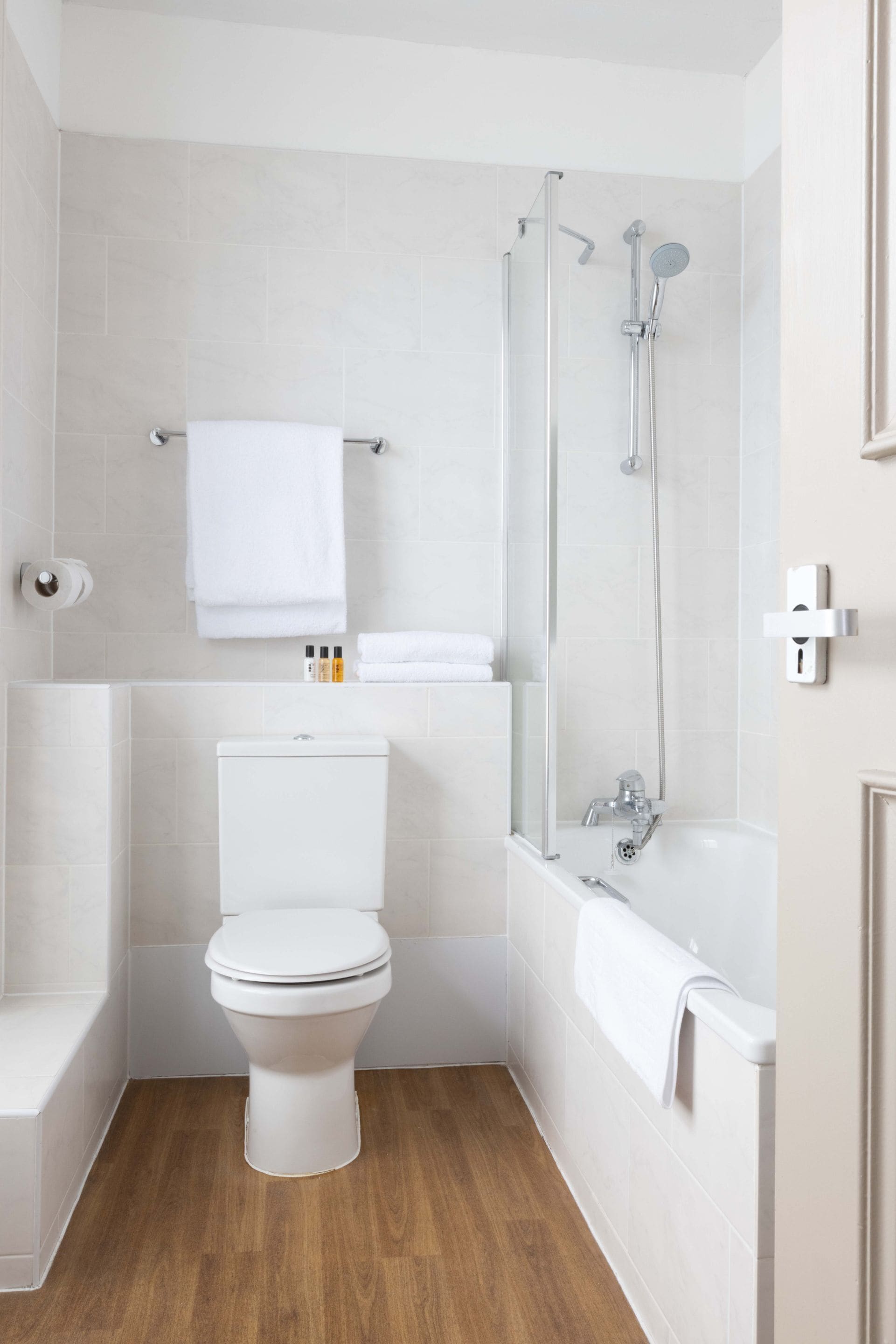 A modern bathroom with a toilet, a bathtub, and a shower.