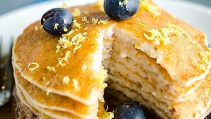 A stack of pancakes with blueberries and syrup. - Cranky Crow Bed and Breakfast (Kodiak)