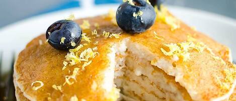 A stack of pancakes with blueberries and syrup.