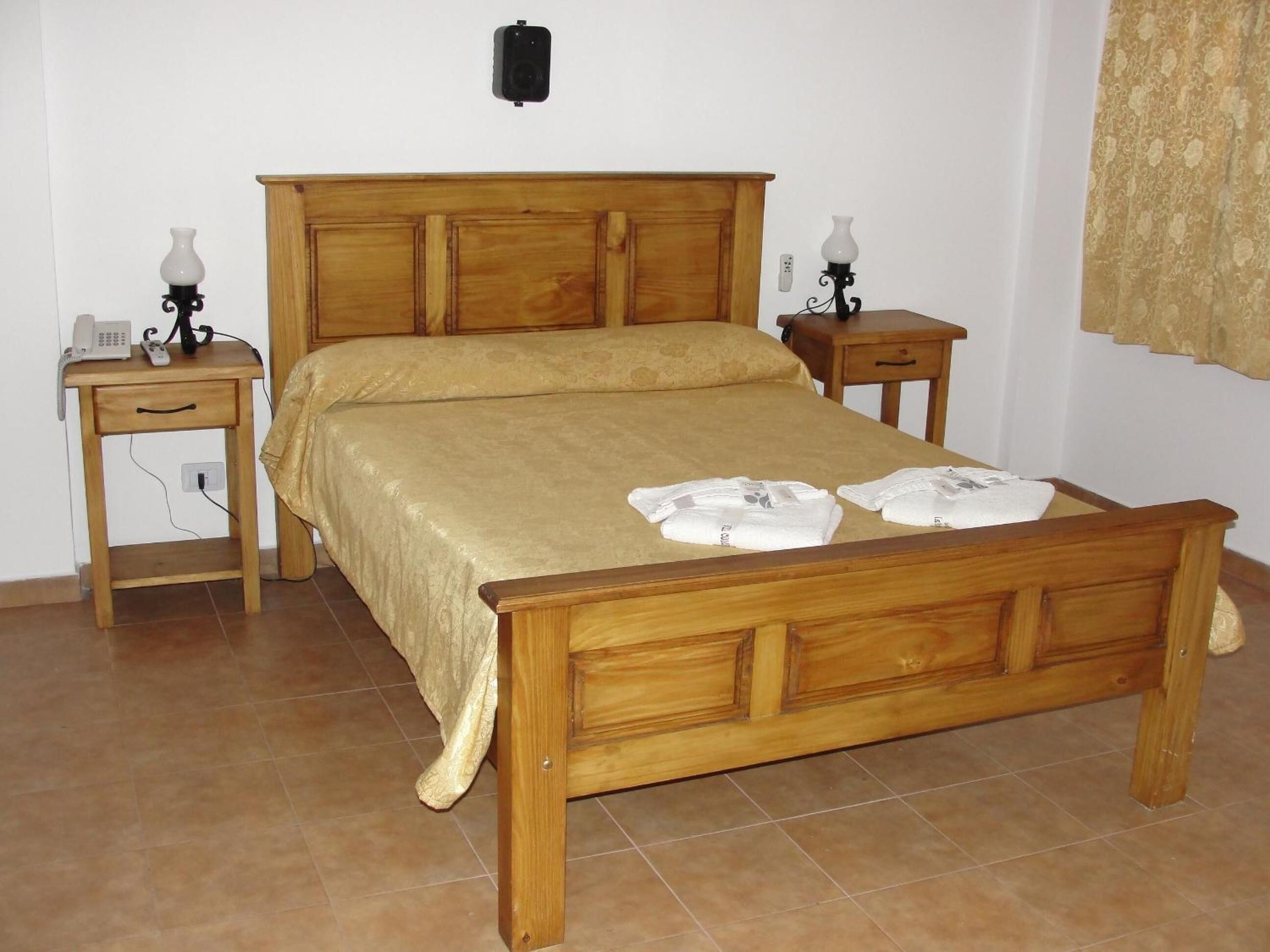 Ein Bett mit Holzkopfstütze, zwei Nachttische und eine Wandleuchte.
