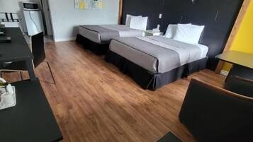 Una habitación de hotel con cama, escritorio, silla y una mesita.