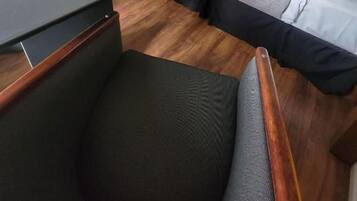 Habitación de hotel con dos camas, un escritorio, una silla, un televisor y un espejo.