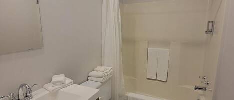 Un baño moderno con lavamanos, inodoro y ducha.