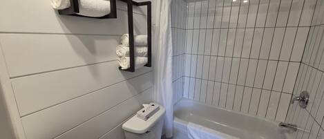 Un baño moderno con inodoro, lavamanos y bañera.