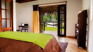 A bedroom with a bed, a desk, and a hammock outside. - Sauce Lodge Laguna Azul (Sauce)