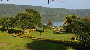 A lush landscape with a lake, trees, and a white fence. - Sauce Lodge Laguna Azul (Sauce)