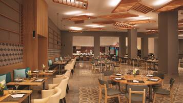 Um restaurante amplo com diversas áreas de refeições, incluindo um bar e um buffet.