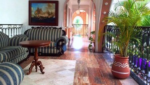 A living room with striped sofas, a wooden coffee table, and a large potted plant. - Canadian Resorts Huatulco (Santa María Huatulco)