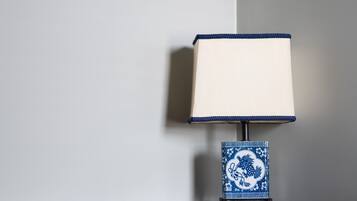A wooden desk with a blue and white patterned lamp and three decorative plates on the wall.