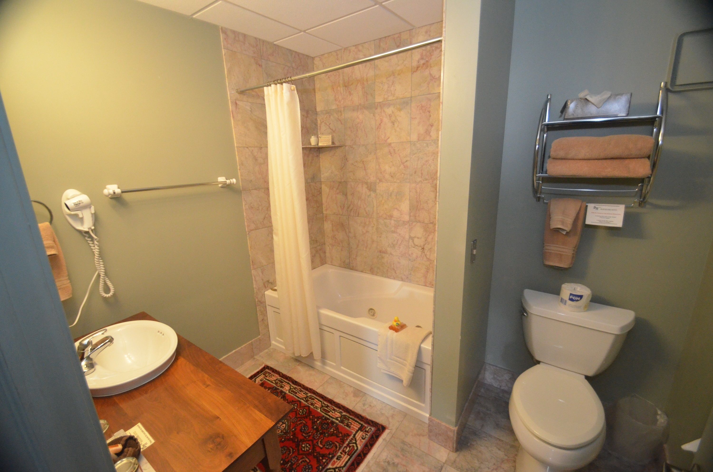 A bathroom with a sink, toilet, bathtub, and shower curtain.