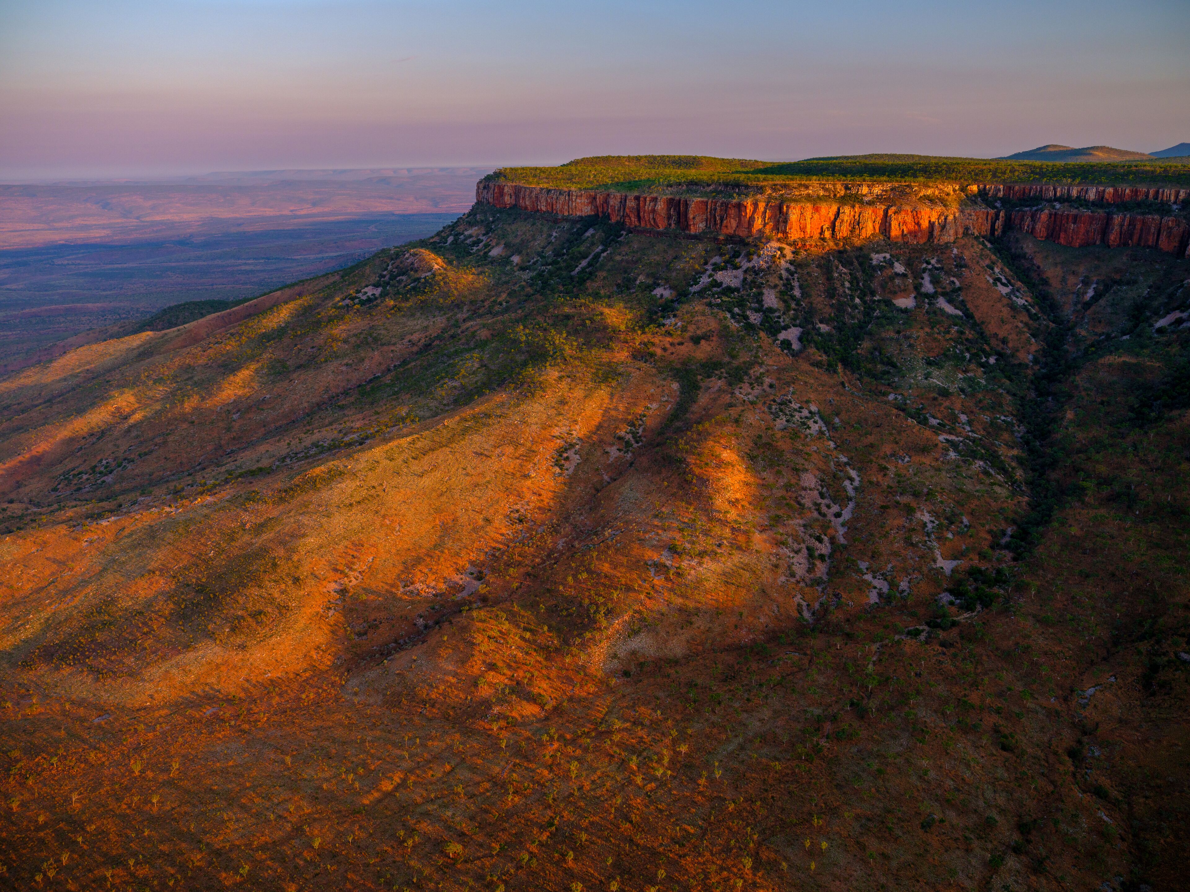 Vista panorâmica de uma paisagem montanhosa com um penhasco imponente.