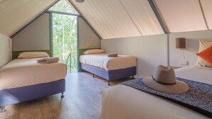 A tented accommodation with three beds, a hanging light fixture, and a view of greenery outside. - El Questro - Emma Gorge (Durack)