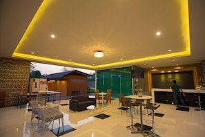 A modern interior with a dining area, seating, and a reception desk.