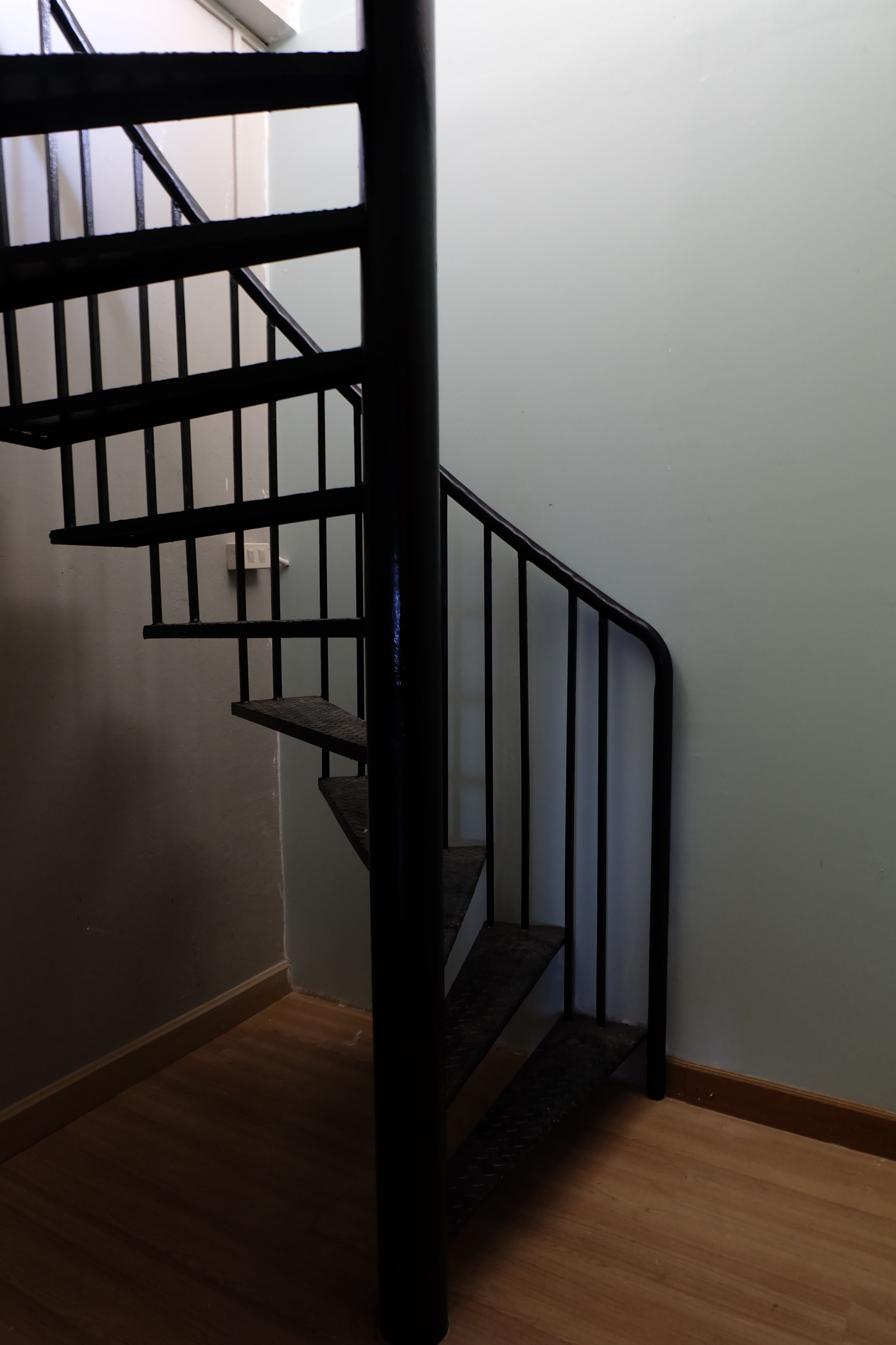 A staircase with black railings and wooden steps.
