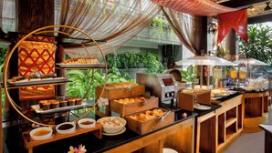 A buffet area with various food items, a coffee station, and a buffet counter with a glass display. - Astagina Resort Villa And Spa (Legian)