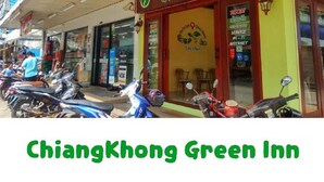 A Green Inn hotel in ChiangKhong Downtown with a signboard, a logo, and a view of the street with parked motorcycles. - Chiangkhong Green Inn Residence (Chiang Khong)