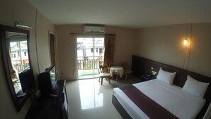 A hotel room with a large bed, a desk with a chair, a small table, a mirror, and a window with curtains. - Chiangkhong Green Inn Residence (Chiang Khong)