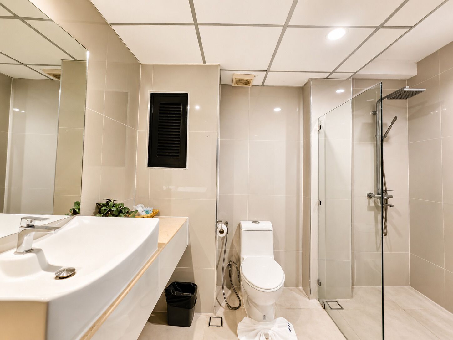 A modern bathroom with a sink, toilet, and glass-enclosed shower.